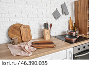 Wooden kitchen counter with cutting boards, electric stove and utensils. Стоковое фото, фотограф Pixel_shot / Фотобанк Лори