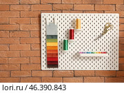 Pegboard with sewing supplies on brick wall in atelier. Стоковое фото, фотограф Pixel_shot / Фотобанк Лори