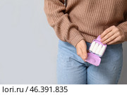 Young woman with tampon box on light background, closeup. Стоковое фото, фотограф Pixel_shot / Фотобанк Лори