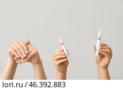 Female hands holding cuticle oil pens on white background. Стоковое фото, фотограф Pixel_shot / Фотобанк Лори