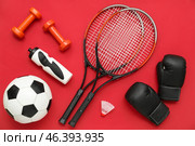 Sport equipment with rackets and boxing gloves on red background. Top view. Стоковое фото, фотограф Pixel_shot / Фотобанк Лори