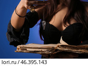 Scary young witch with spell book on color background, closeup. Стоковое фото, фотограф Pixel_shot / Фотобанк Лори
