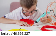 Boy drawing with 3D pen at table. Стоковое видео, видеограф Igor Skripachev / Фотобанк Лори