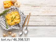 Baking dish with tasty julienne and ingredients on light wooden background. Стоковое фото, фотограф Pixel_shot / Фотобанк Лори