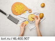 Woman preparing tasty potato casserole in ramekin on light background. Стоковое фото, фотограф Pixel_shot / Фотобанк Лори