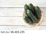 Basket with fresh zucchini squashes on light wooden background. Стоковое фото, фотограф Pixel_shot / Фотобанк Лори