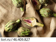Tasty raw artichokes on sackcloth. Стоковое фото, фотограф Pixel_shot / Фотобанк Лори