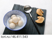 Bamboo mat with bowl of tangyuan and cookies on white background. Dongzhi Festival. Стоковое фото, фотограф Pixel_shot / Фотобанк Лори