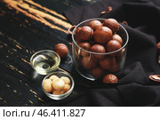 Tasty macadamia nuts with oil on dark wooden background. Стоковое фото, фотограф Pixel_shot / Фотобанк Лори