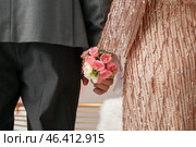 Young woman with corsage and her prom date holding hands, closeup. Стоковое фото, фотограф Pixel_shot / Фотобанк Лори