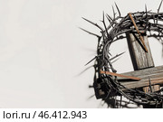 Crown of thorns with wooden cross and nails on light background, closeup. Стоковое фото, фотограф Pixel_shot / Фотобанк Лори