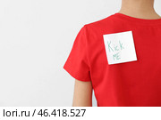 Sticky note with text KICK ME on back of little boy against light background. April Fools' Day celebration. Стоковое фото, фотограф Pixel_shot / Фотобанк Лори