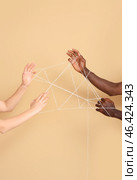 Hands of Caucasian woman and African-American man with ropes on color background. Racism concept. Стоковое фото, фотограф Pixel_shot / Фотобанк Лори