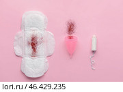 Menstrual pad, cup and tampon with red glitter on color background. Menstruation concept. Стоковое фото, фотограф Pixel_shot / Фотобанк Лори