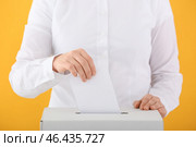 Голосующая женщина возле урны на цветном фоне. Стоковое фото, фотограф Pixel_shot / Фотобанк Лори