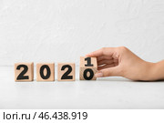 Женская рука превращает фигуру 2020 в 2021 на белом фоне. Стоковое фото, фотограф Pixel_shot / Фотобанк Лори