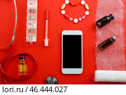 Современный мобильный телефон с врачебными принадлежностями на цветном фоне. Стоковое фото, фотограф Pixel_shot / Фотобанк Лори