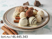Тарелка с вкусными сладкими трюфелями и корицей на светлом фоне. Стоковое фото, фотограф Pixel_shot / Фотобанк Лори