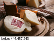 Деревянная доска с ассортиментом вкусных сыров на столе. Стоковое фото, фотограф Pixel_shot / Фотобанк Лори