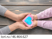 Мать и дитя с войлочным сердцем на деревянном фоне. Стоковое фото, фотограф Pixel_shot / Фотобанк Лори