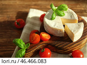Вкусный сыр бри с базиликом и помидорами черри на столе. Стоковое фото, фотограф Pixel_shot / Фотобанк Лори