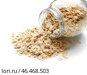Опрокинутая стеклянная банка с сырой овсянкой на белом фоне, крупным планом. Стоковое фото, фотограф Pixel_shot / Фотобанк Лори