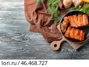 Сковорода с вкусными ребрышками на деревянном столе. Стоковое фото, фотограф Pixel_shot / Фотобанк Лори
