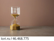 Песочные часы на столе фоне цвета. Концепция тайм-менеджмента. Стоковое фото, фотограф Pixel_shot / Фотобанк Лори