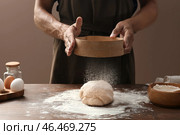Человек просеивает муку на тесто на цветном фоне. Стоковое фото, фотограф Pixel_shot / Фотобанк Лори