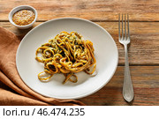 Тарелка вкусных макарон с соусом песто на деревянном столе. Стоковое фото, фотограф Pixel_shot / Фотобанк Лори