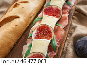 Вкусный бутерброд с спелый инжир, прошутто и сыр бри на деревянной доске, крупным планом. Стоковое фото, фотограф Pixel_shot / Фотобанк Лори