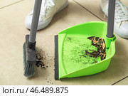 Женщина подметает плиточный пол совком и веником, крупным планом. Стоковое фото, фотограф Pixel_shot / Фотобанк Лори