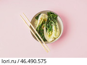 Чаша вкусной тушеной капусты пак-чой и палочками на розовом фоне. Стоковое фото, фотограф Pixel_shot / Фотобанк Лори