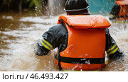 Firefighter rescuing people during flood disaster, wearing life vest and helmet. Стоковое AI-изображение, AI-художник Юрий Поздников / Фотобанк Лори