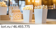 Popcorn buckets overflowing with tasty kernels await moviegoers. Стоковое AI-изображение, AI-художник Юрий Поздников / Фотобанк Лори