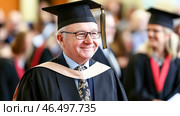 Proud professor smiling at graduation ceremony. Стоковое AI-изображение, AI-художник Юрий Поздников / Фотобанк Лори
