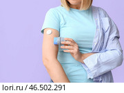 Женщина с глюкозным датчиком для измерения уровня сахара в крови и аппликатором на лиловом фоне. Концепция диабета. Стоковое фото, фотограф Pixel_shot / Фотобанк Лори