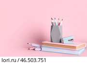 Карандашница с фломастерами и книга на розовом фоне. Стоковое фото, фотограф Pixel_shot / Фотобанк Лори