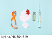 Изображение человеческой головы из бумаги с пазлом, ампулой, шприцем и оранжевой лентой на синем фоне. Месяц осведомленности о рассеянном склерозе. Стоковое фото, фотограф Pixel_shot / Фотобанк Лори