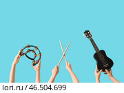 Женщина с бубном, барабанными палочками и укулеле на синем фоне. Стоковое фото, фотограф Pixel_shot / Фотобанк Лори