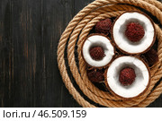 Веревка со вкусным кокосом и рамбутаном на темном столе. Стоковое фото, фотограф Pixel_shot / Фотобанк Лори