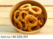 Картонная миска с вкусными луковыми кольцами на деревянном столе. Стоковое фото, фотограф Pixel_shot / Фотобанк Лори