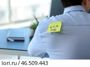Записки с текстом пнуть меня на спине человека, работающего в офисе. Первоапрельская шутка. Стоковое фото, фотограф Pixel_shot / Фотобанк Лори