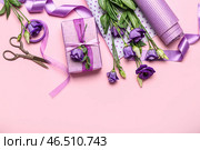 Композиция с подарочной коробкой, оберточной бумагой, лентами и красивыми цветами эустомы на розовом фоне. Празднование женского дня. Стоковое фото, фотограф Pixel_shot / Фотобанк Лори
