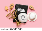 Композиция к Хануке с Торой, кипой, менаорой и пончиком на розовом фоне. Стоковое фото, фотограф Pixel_shot / Фотобанк Лори