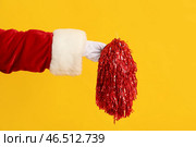 Рука Санта с помпоном на желтом фоне, крупным планом. Стоковое фото, фотограф Pixel_shot / Фотобанк Лори