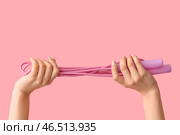 Женские руки с скакалкой на розовом фоне. Стоковое фото, фотограф Pixel_shot / Фотобанк Лори