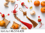 Композиция с амулетами удачи, печеньями с предсказаниями, мандаринами и китайскими символами на белом фоне. Празднование Нового года. Стоковое фото, фотограф Pixel_shot / Фотобанк Лори