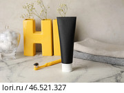 Черная зубная паста с активированным углем, щетка и полотенца на столе. Стоковое фото, фотограф Pixel_shot / Фотобанк Лори