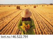 Романтичная девушка с подсолнухами на фоне убранного поля. Стоковое фото, фотограф Pixel_shot / Фотобанк Лори